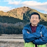 高城山を背にした山口喜昭さん。江戸時代、山には藩有林があり、収穫されたマツタケが幕府へも献上されたという＝丹波篠山市内