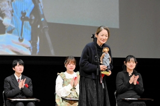 大賞に選ばれた大永恵子さん（右から２番目）。主人公の人形「きりさん」を手に感謝の言葉を述べる＝四季の森生涯学習センター