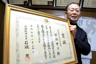 首相の名前が書かれた賞状を手にする村岡孝司さん＝丹波市柏原町柏原