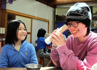 参加した小学生（左）が作った万華鏡をのぞくボランティア＝丹波篠山市小田中