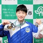 ジュニア五輪出場を決めた際のメダルを掲げ、健闘を誓う足立雄星さん＝丹波市氷上町成松