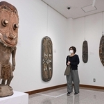 植野記念美術館の創設者、植野藤次郎さんらによる「エンバ探検隊」が収集した神像付きの台座や仮面＝植野記念美術館