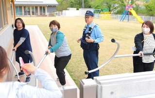 警察官に教わり、門前で不審者を食い止める方法を実践する職員たち＝こんだ認定こども園