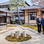 住宅を改装した宿泊施設「豆家」（奥の２棟）や枯山水の庭と小田垣昇社長（左）ら＝丹波篠山市立町