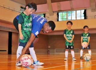 三國スティビアエブス選手（左から２人目）からボールの蹴り方などを教わる子どもら＝丹波市市島町上田