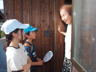 「困っていることはないですか」。玄関先の立ち話で交流する子どもたち＝丹波市氷上町稲畑