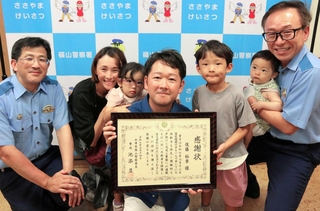 高齢男性の人命保護に貢献し、署長感謝状を受けた後藤裕章さん（中央）。家族らに囲まれ喜びの表情を見せた＝丹波篠山市郡家