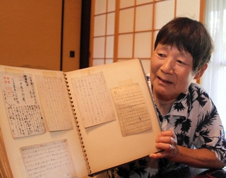 叔父の小中臣夫さんが残したはがきを見る西垣佳世子さん＝丹波篠山市味間奧