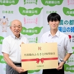 日本ジュニアトライアスロン選手権に出場し、「丹波篠山ふるさとＰＲ奨励金」を受け取った河口航生さん（右）＝丹波篠山市役所