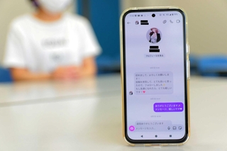 ＳＮＳのメッセージをきっかけに詐欺被害に遭いかけた経験を振り返る女性（奥）。手前は最初に送られてきたメッセージ＝丹波篠山市内（画像を一部加工）