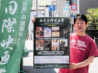 ポスターを掲げる近兼拓史さん＝丹波市氷上町成松