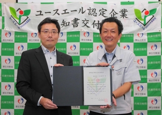 ユースエール認定の通知書を笑顔で受け取る氷上製作所の菓子俊之社長（右）＝丹波市氷上町石生