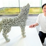 自作「朧気（狼）」の横に並ぶ秋永邦洋さん＝兵庫陶芸美術館