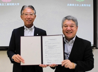 協定書を取り交わした飯田有二学長（左）と長尾均校長＝丹波市春日町黒井