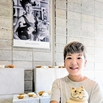 若き日のリサ・ラーソンさんの写真を前に、彼女がデザインした猫の置物を手にする大上彩子さん＝昇陽窯