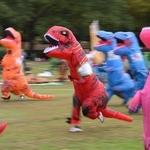 恐竜の着ぐるみ姿で走るティラノサウルスレースの参加者ら＝丹波年輪の里