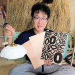 丹波篠山ですいた和紙を手にする大西祐一郎さん。和紙を活字で印刷し装飾したり、ランプシェードにしたりする試みも＝丹波篠山市黒田