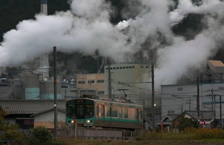 夕暮れの中、工場を背に走る加古川線の電車＝丹波市山南町谷川