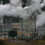 夕暮れの中、工場を背に走る加古川線の電車＝丹波市山南町谷川
