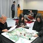 リハーサルでこたつを搬入し、ゲームや読書を楽しむ人たち＝丹波市氷上町常楽