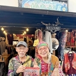 「だいじょうぶ屋」の前で、４０周年セレモニーのチラシを手にする岩下八司さん（左）と妻・啓子さん＝丹波篠山市呉服町