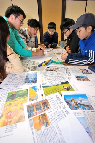 丹波篠山市に関する記事からキーワードを選び出し、謎解き問題を考える児童ら＝丹波篠山市黒岡、春日神社