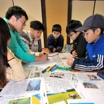 丹波篠山市に関する記事からキーワードを選び出し、謎解き問題を考える児童ら＝丹波篠山市黒岡、春日神社