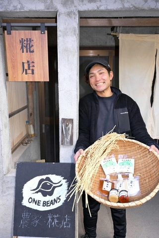 販売所の前で笑顔を見せるワンビーンズの村上玄一さん＝丹波篠山市西古佐