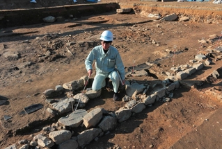 発掘調査で見つかった石組遺構と礎石。「崇広館」の講堂跡とみられ、手前が縁辺で奥へと建物があったと考えられる＝丹波市柏原町柏原