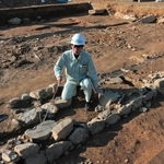 発掘調査で見つかった石組遺構と礎石。「崇広館」の講堂跡とみられ、手前が縁辺で奥へと建物があったと考えられる＝丹波市柏原町柏原