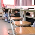 机の下に潜り込み、頭を守る子どもら＝北小学校