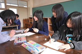 地域のシンボルなどを題材にオリジナルキャラクターを描く児童ら＝進修小学校