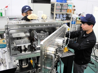 試料に電子ビームを当てる装置を組み立てる技術者＝丹波市氷上町沼