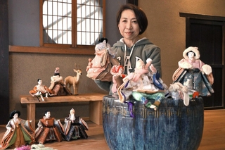 展示中の人形を手にする衣川百合香さん＝丹波市青垣町佐治