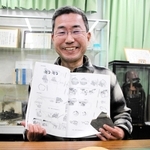 報告書を手にする東昭吾さん。手前には発見した破片の一部が並ぶ＝丹波市内