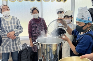 作り手だった地域の女性らに教わり、ビーンズサワーを試作する児童たち＝２月１８日、西紀北小学校（同校提供）