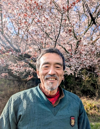 樹齢２００年はあるという古木「大石桜」の前に立つ吉良勉さん＝丹波篠山市古市