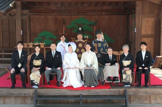 重要文化財の能舞台で温かな神前結婚式を行い、記念写真に納まる新郎新婦ら＝春日神社