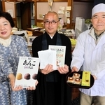 「栗まんじゅう　えくぼ」を販売する畑さん夫婦と、１００の法話を考えた安達住職（中央）＝丹波篠山市乾新町
