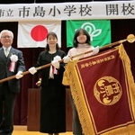 真新しい校旗を受け取り、記念写真に収まる児童代表ら＝市島小学校