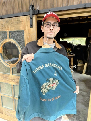 図柄のデザインと刺繡を手がけた服を手にする坂本崚さん＝丹波篠山市小中