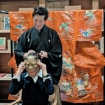 能楽師の上田宜照さんに能面を着けてもらう女性＝豆家