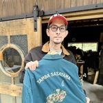 図柄のデザインと刺繡を手がけた服を手にする坂本崚さん＝丹波篠山市小中