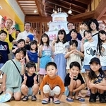大きなバースデーケーキを前に記念撮影する入館者やスタッフら＝篠山チルドレンズミュージアム（提供）