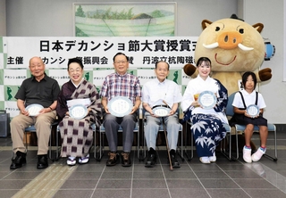 歌詞が記された丹波焼の皿を手にする村岡孝司さん（左から３人目）ら入賞者＝丹波篠山市役所