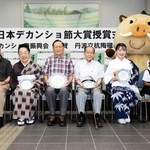 歌詞が記された丹波焼の皿を手にする村岡孝司さん（左から３人目）ら入賞者＝丹波篠山市役所