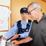 電話機に取り付けた録音機の状態を確かめる菅野秀昭警部補（左）＝丹波篠山市内