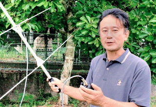 サルの位置情報を調べるためのアンテナを手にする鈴木克哉さん＝丹波篠山市味間新