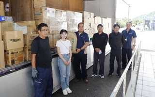北野有作さん（左端）や野上鈴さん（左から２人目）らが立ち合う中、支援物資を受け取る熊本県芦北町の松本俊造副町長（同３人目）＝同町（芦北町提供）