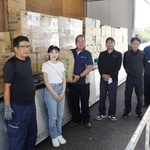 北野有作さん（左端）や野上鈴さん（左から２人目）らが立ち合う中、支援物資を受け取る熊本県芦北町の松本俊造副町長（同３人目）＝同町（芦北町提供）